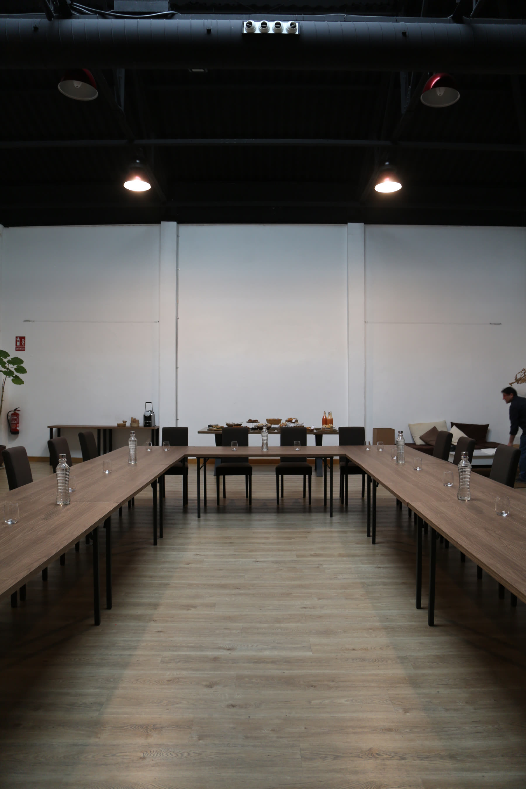 Sala montada en aula con mesas corridas para una formación