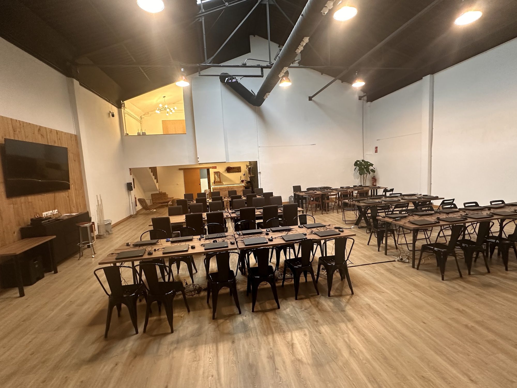 Banquete montado con mesas vestidas y cristalería en la sala principal